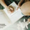 Mutter schreibt neben ihrem Baby Erinnerungen in das Mriella Babytagebuch
